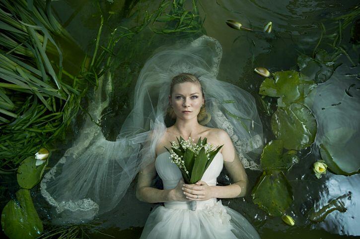 Passion of Arts: Justine trägt ein Brautkleid und liegt im Teich, starrt dabei in den Himmel