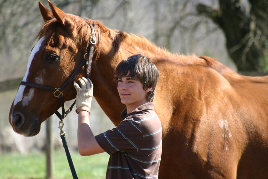 Passion of Arts: Patrick McCardle steht neben seinem Pferd und lächelt