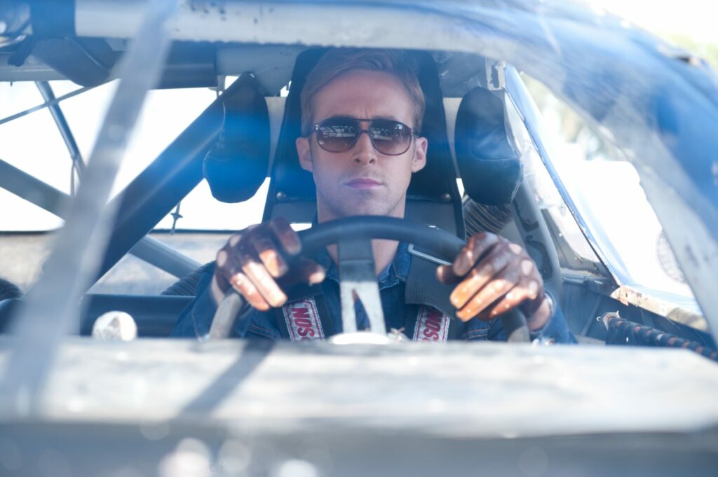 Top 5 Ryan Gosling Performances: Der Driver sitzt in seinem Auto am Steuer, trägt eine Sonnenbrille und Handschuhe