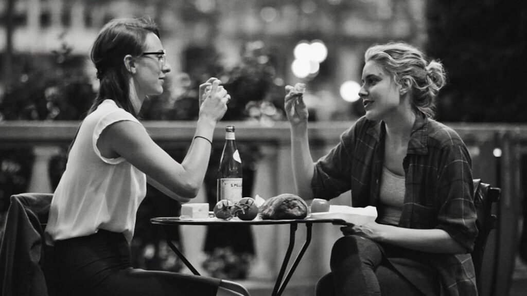 Die 5 besten Sommer in der Stadt Filme: Sophie sitzt links, rechts sitzt Frances. Die beiden essen zusammen auf der Terrasse eines Restaurants