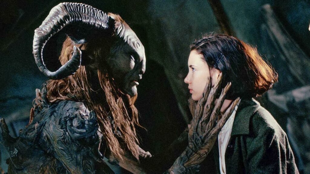 Epische Fantasy-Filme: Links ist der Faun. Ihm gegenüber steht Ofelia, die beiden sehen sich an. Der Faun hat seine Hände auf ihr Gesicht gelegt und scheint zu ihr zu sprechen