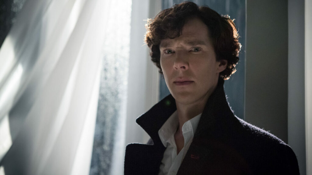 Ikonische Vorbilder: Sherlock steht an einem Fenster. Er trägt seinen ikonischen Mantel und hat die Stirn gerunzelt