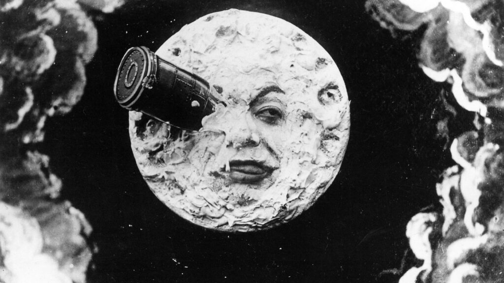 Das Bild Zeigt einen Mond mit einem Menschengesicht. In einem Auge hat es eine Rakete