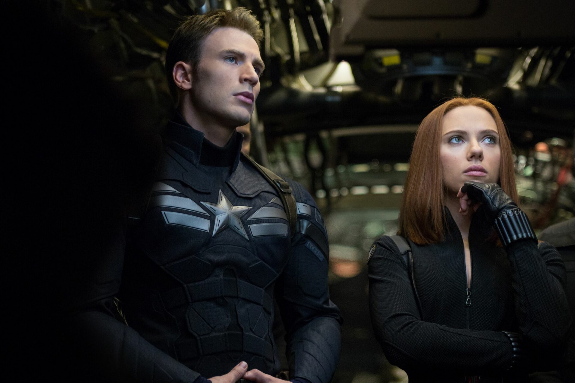 Film-Ensembles: Links steht Chris Evans in seinem Captain America Kostüm. Neben ihm ist Scarlett Johansson, die ihre Hand an ihr Kinn gelegt hat. Beide überlegen etwas