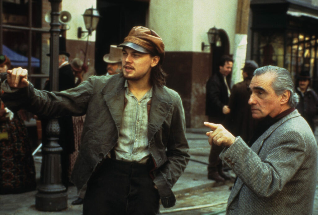 Film-Ensembles: Auf dem Bild ist Leonardo DiCaprio auf der linken Seite. Er deutet mit dem kleinen Finger in eine Richtung und fragt Martin Scorsese etwas, der neben ihm steht und ebenfalls in die Richtung deutet