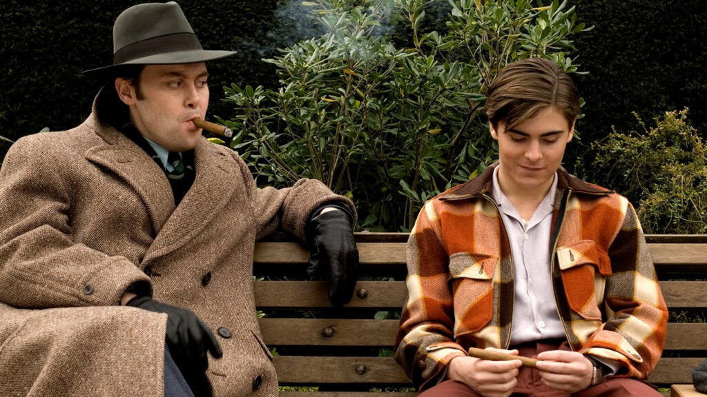 Die 5 besten Film- oder Serienadaptionen von Büchern: Auf dem Bild sitzen zwei Männer auf der Bank. Der eine raucht eine Zigarre, der andere dreht eine in seinen Händen