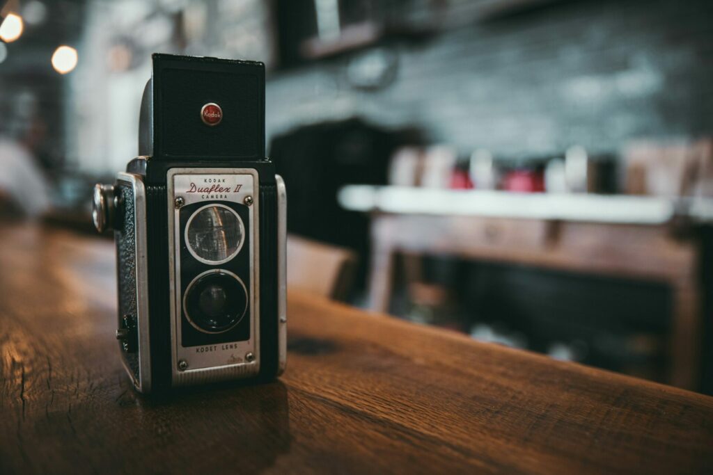 Kameraarbeit: Das Bild zeigt eine kleine Kamera, die auf einem Holztisch steht