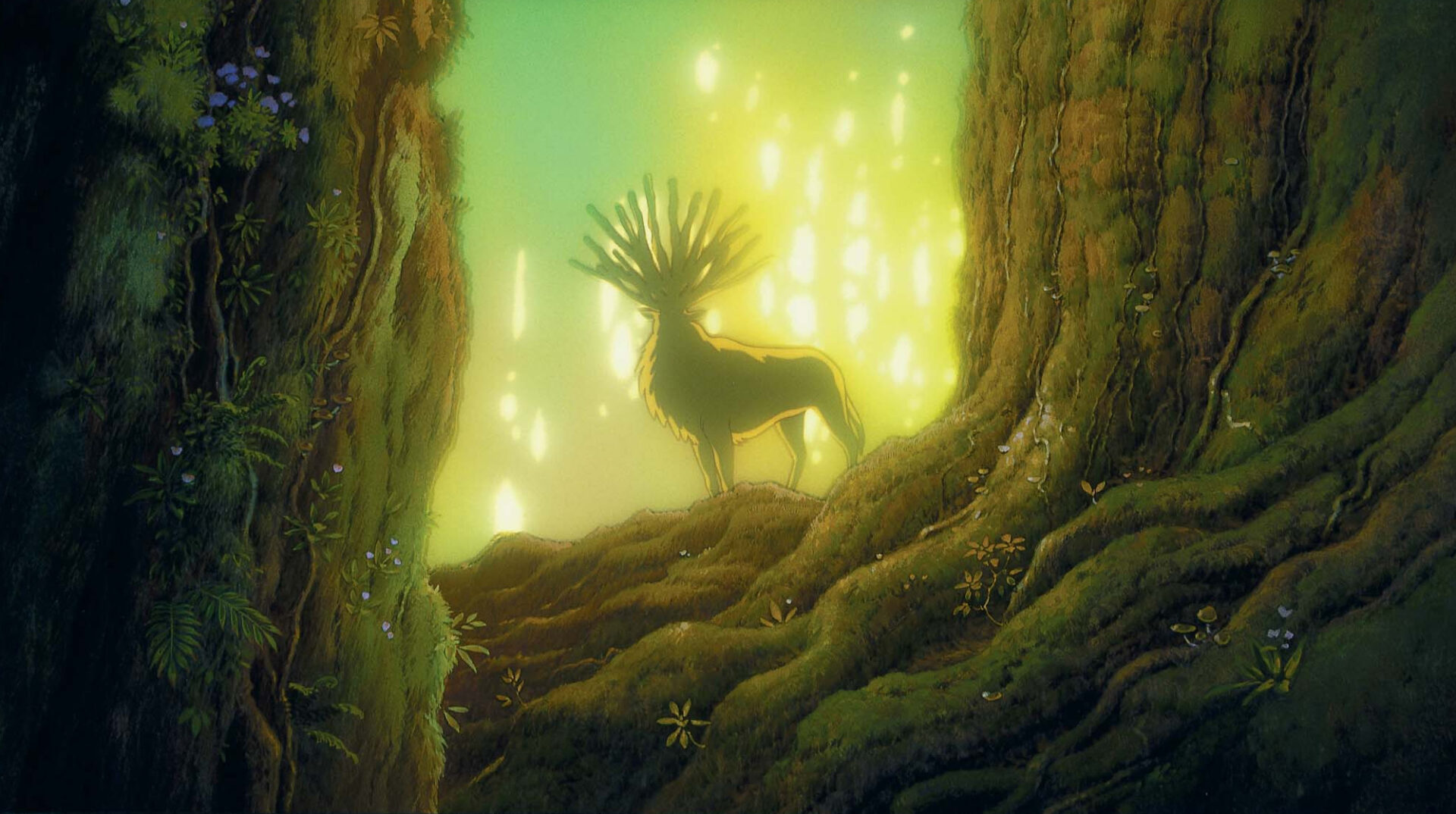 Prinzessin Mononoke: Das Bild zeigt einen Hirsch mit einem mit einem Geweih mit 13 Enden. Er steht zwischen zwei großen Bäumen, hinter ihm leuchtet die Sonne golden
