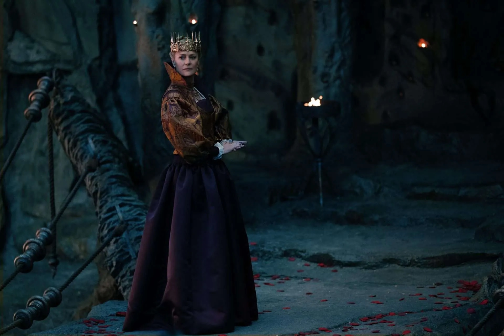 Auf dem Bild ist eine stattliche Königin zu sehen, die vor einem Höhleneingang steht