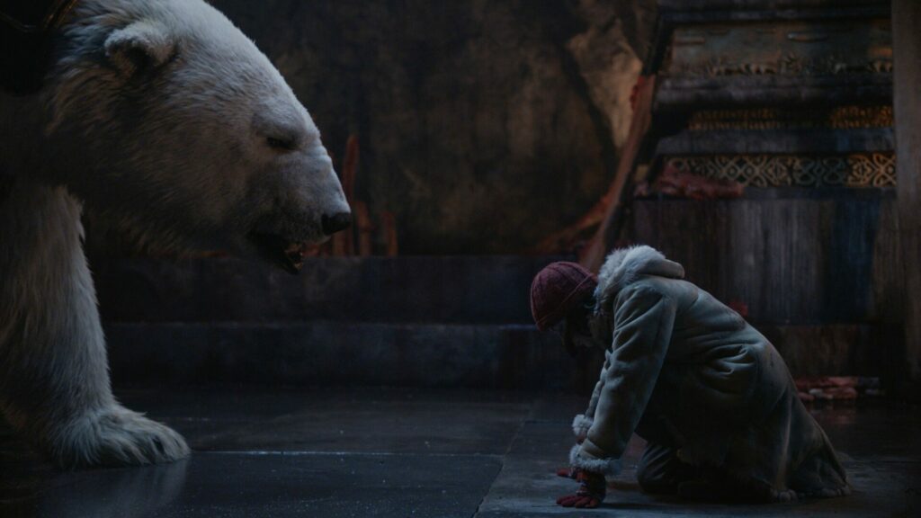 Auf dem Bild ist ein Eisbär zu sehen und ein Mädchen, das vor ihm kniet