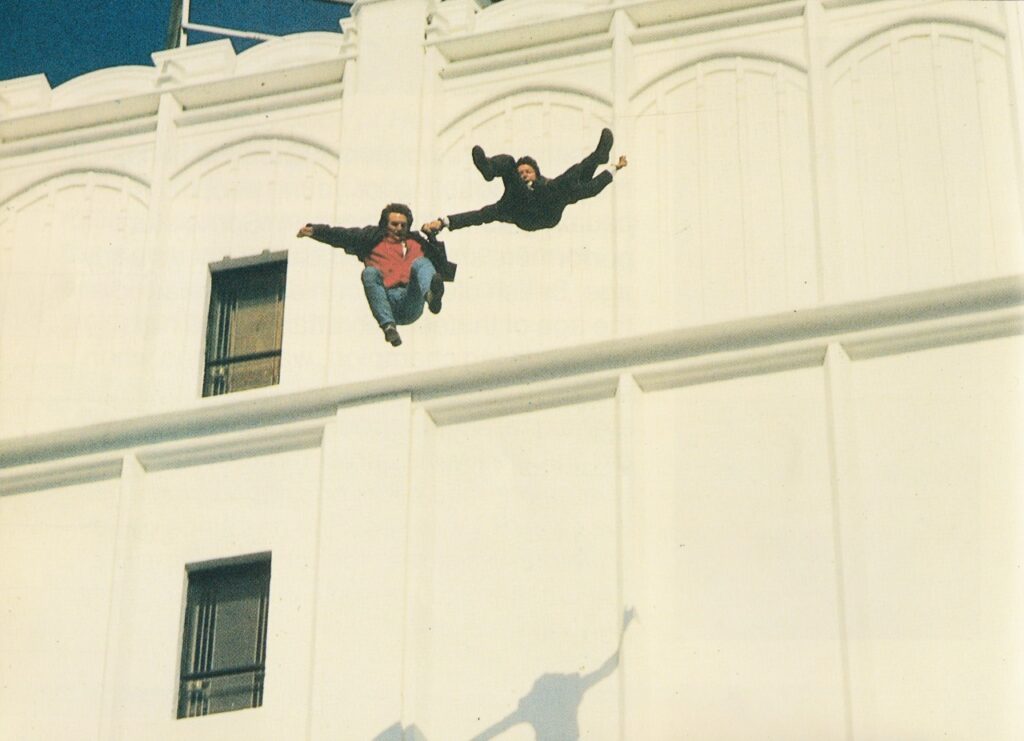 Die besten Action-Filme mit spektakulären Stunts: Auf dem Bild sieht man zwei Männer, die Hand in Hand von einem Gebäude springen