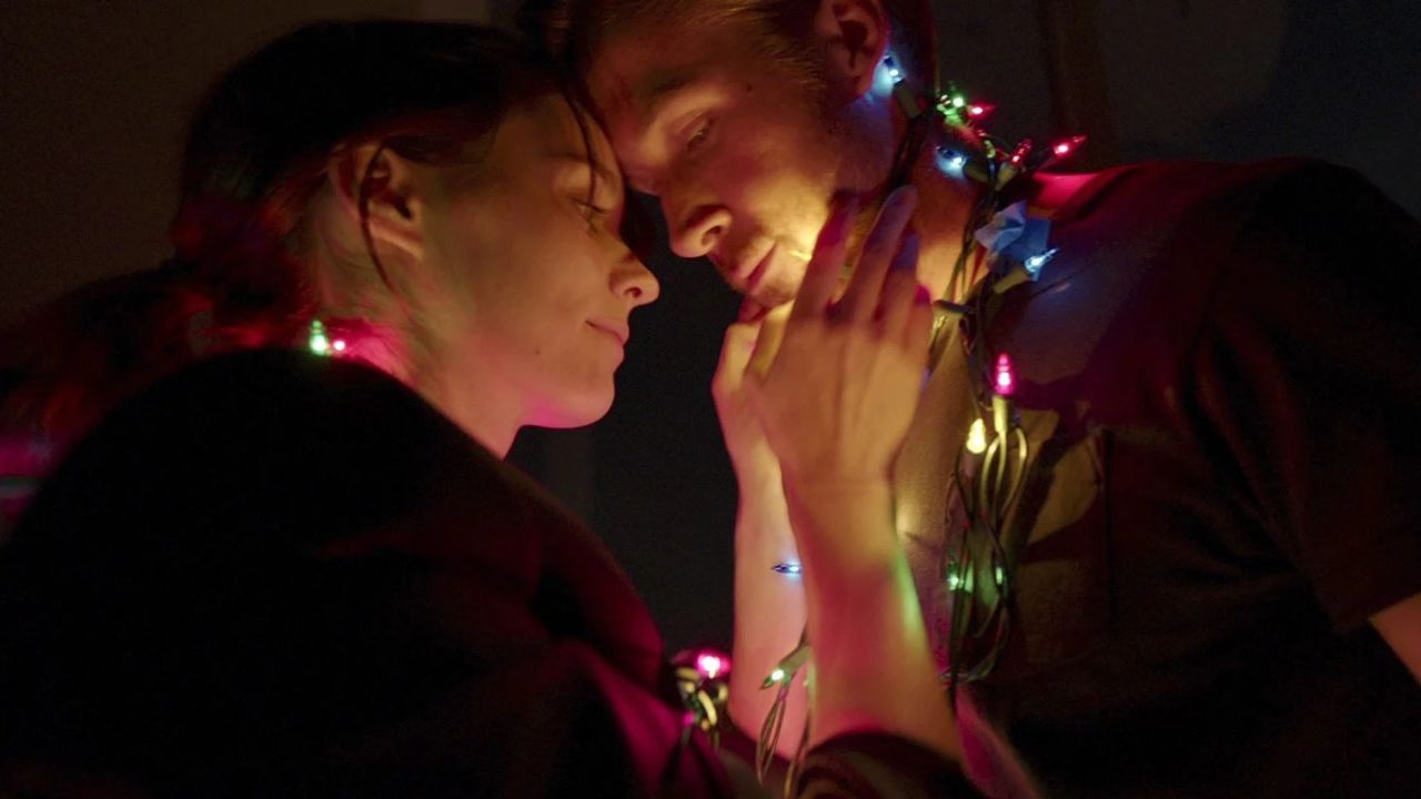 Song to Song: Das Bild zeigt einen Mann und eine Frau. Er hat eine Lichterkette um den Hals, die sich auch um ihren Schlängelt. Sie hat liebevoll sein Gesicht in ihren Händen