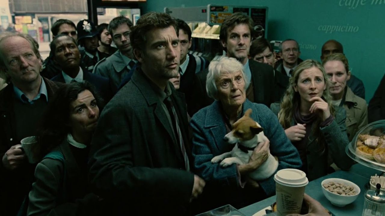 Children of Men: Auf dem Bild ist eine Menschenmenge, die in einem Coffeeshop vor dem Tresen stehen und auf etwas hinauf blicken