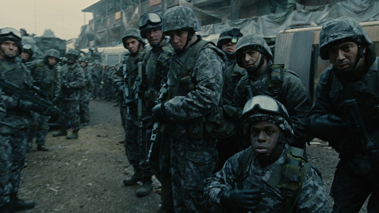 Children of Men: Das Bild zeigt Soldaten, die in der Reihe stehen. Einer kniet ehrfürchtig