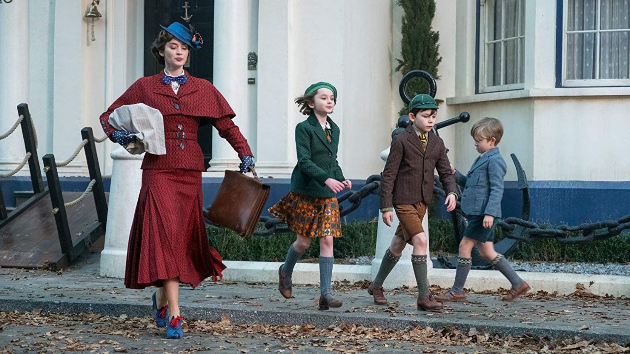 Mary Poppins’ Rückkehr: Auf dem Bild ist eine Frau in einem roten Kostüm und einem blauen Hut. Neben ihr gehen drei Kinder
