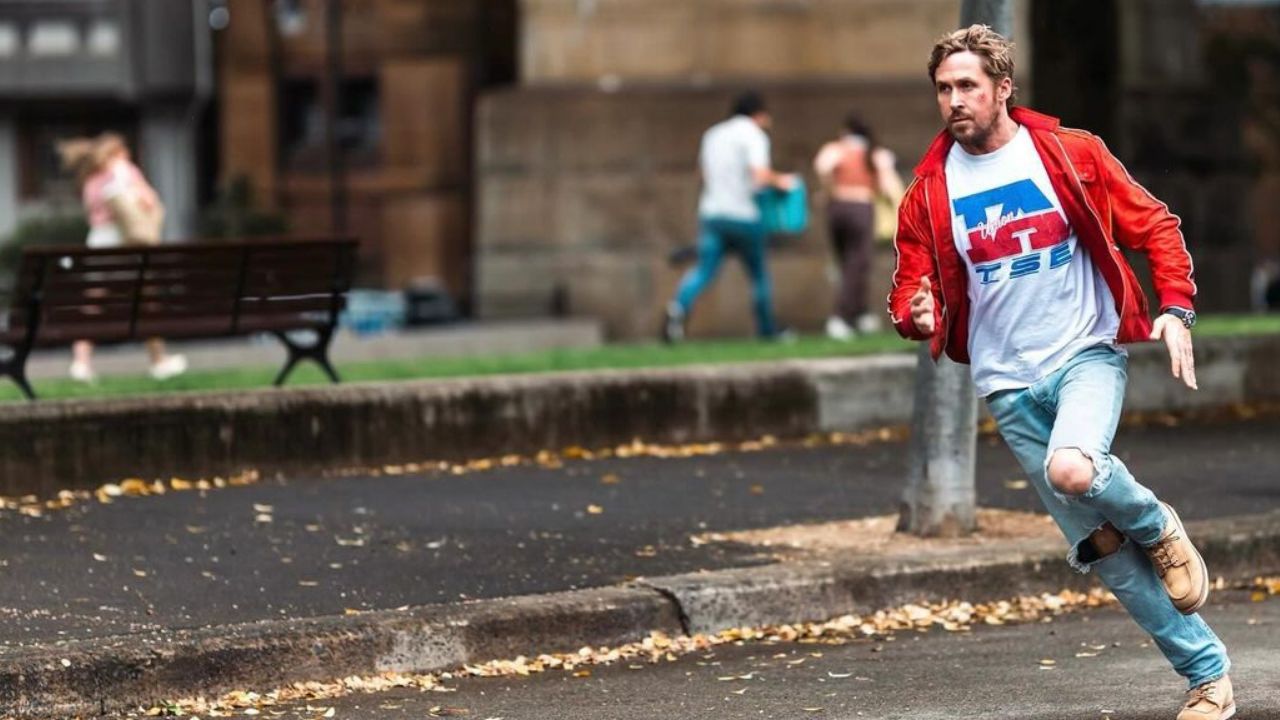 The Fall Guy: Auf dem Bild ist ein Mann mit roter Jacke und weißem T-Shirt. Seine Jeans hat an den Knien Löcher. Er rennt gerade eine Straße entlang