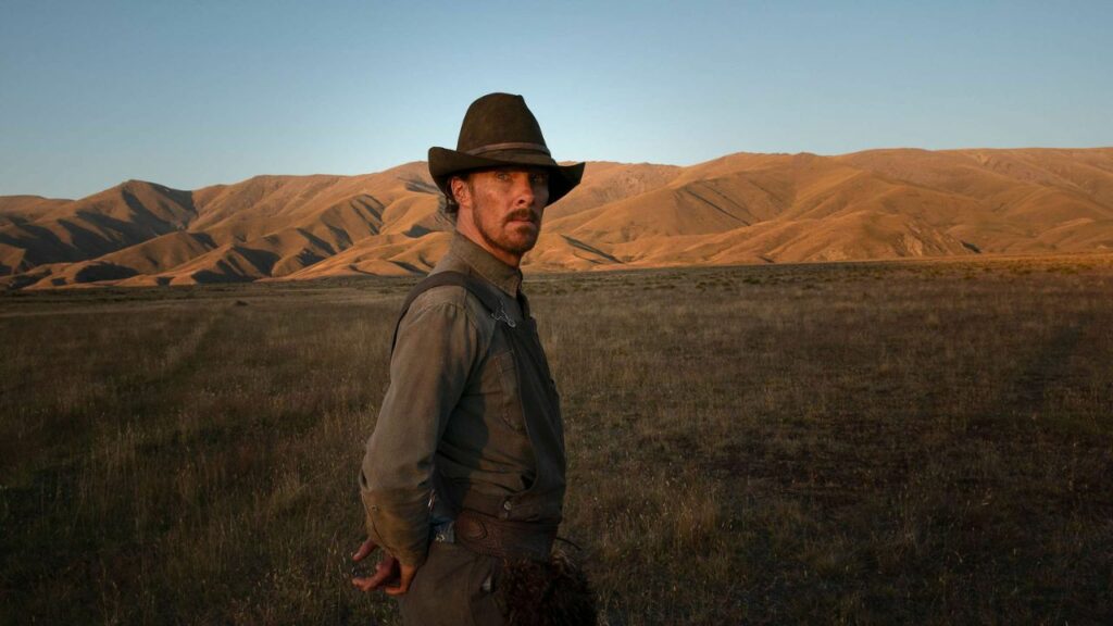 Das Bild zeigt einen Cowboy in der Prärie, der stattlich posiert. Im Hintergrund sind viele Hügel zu sehen