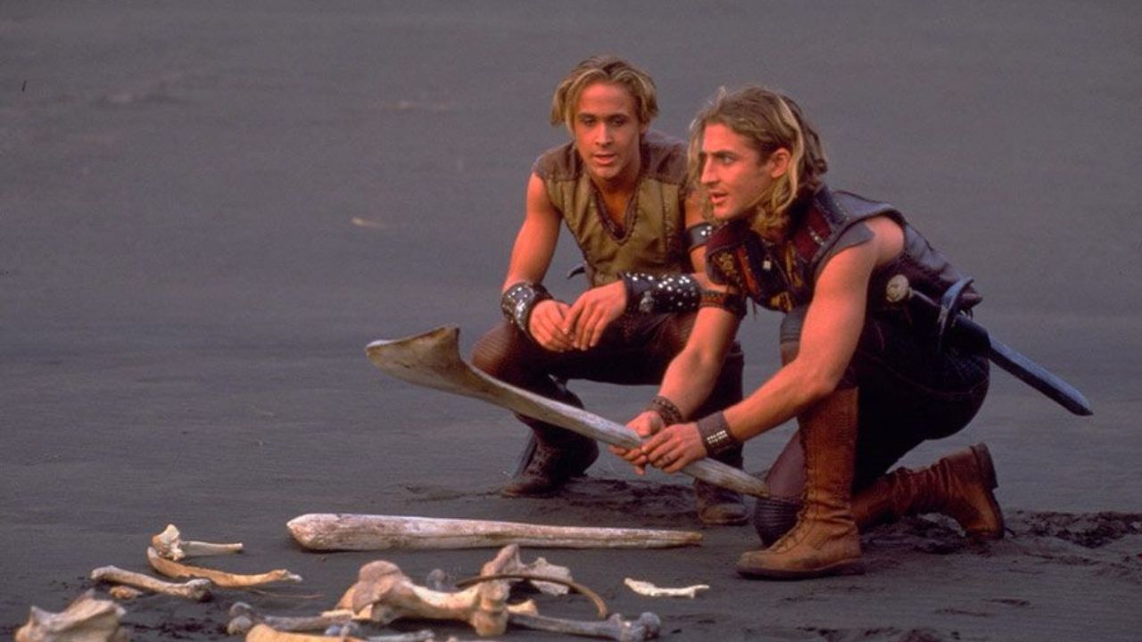 Das Bild zeigt zwei junge Männer, die in einer Wüstenlandschaft vor einem Knochenhaufen knien. Einer davon hat einen langen Knochen in die Hand genommen