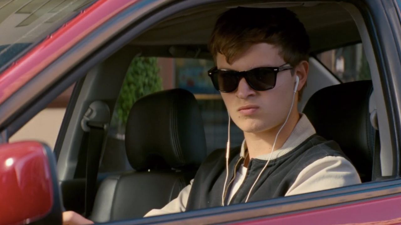 Baby Driver: Das Bild zeigt einen jungen Mann am Steuer eines Autos. Er trägt Kopfhörer und eine Sonnenbrille.