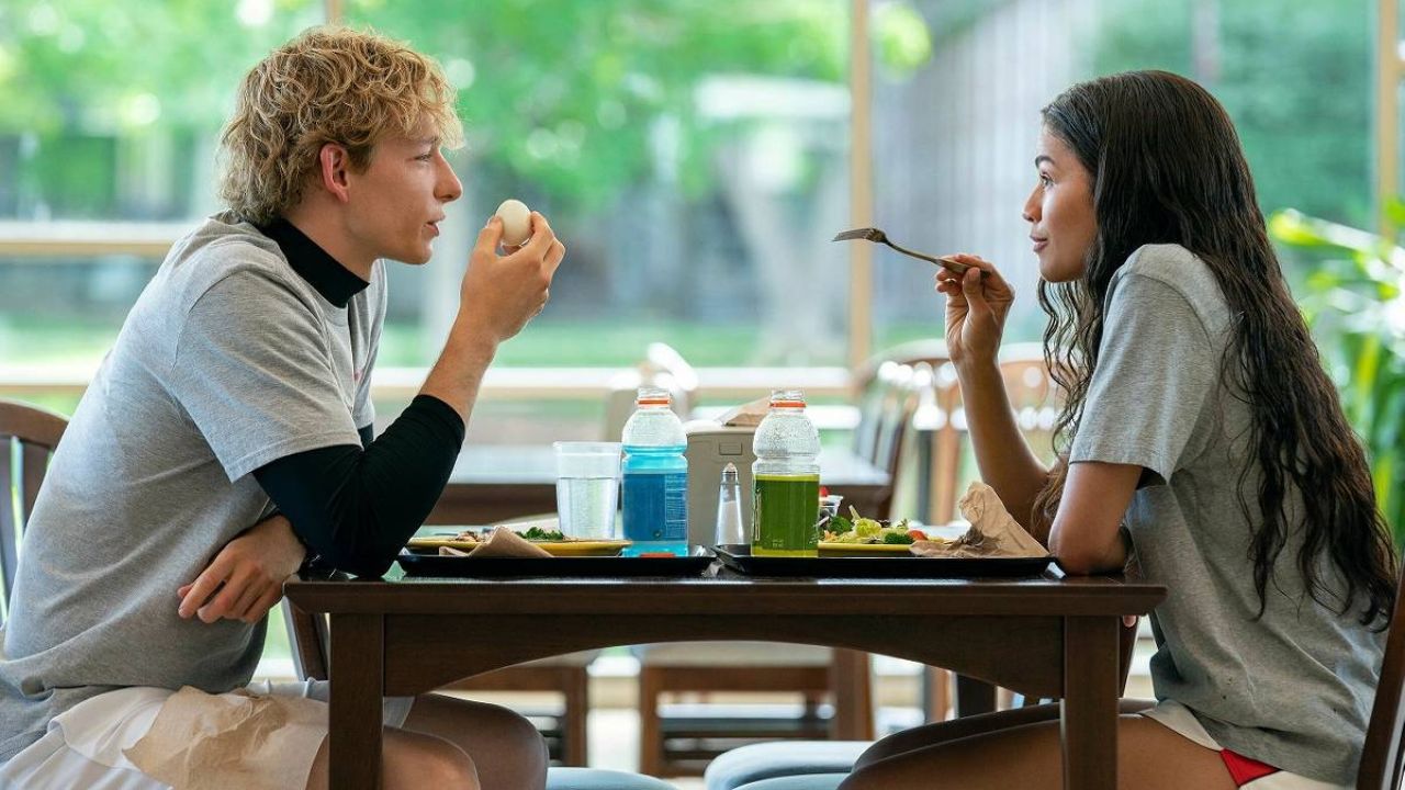 Challengers: Das Bild zeigt eine Frau und einen Mann, die sich beim Essen gegenüber sitzen. Er hält soeben ein Ei in der Hand und sie hält die Gabel vor sich und sagt etwas