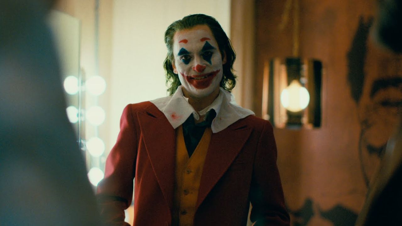 Joker: Das Bild zeigt einen Clown, der in einer Garderobe steht und fies lächelt