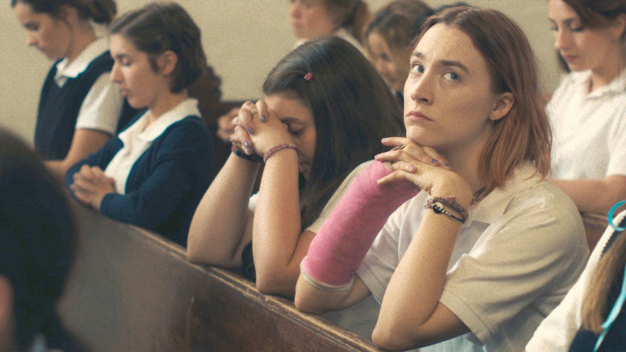 Das Bild zeigt betende Mädchen, die in der Kirchenbank sitzen. Ein Mädchen trägt einen rosa Gipsarm und schaut nach nachdenklich