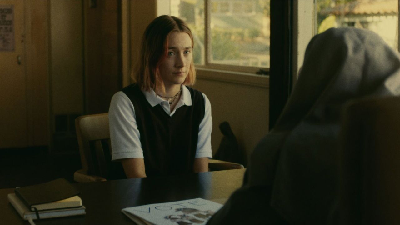Das Bild zeigt eine junge Frau in Schuluniform, die vor einem Schreibtisch sitzt