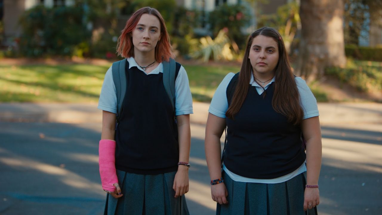 Lady Bird: Auf dem Bild sind zwei Junge Frauen in Schuluniform. Die links im Bild trägt einen rosa Gipsarm