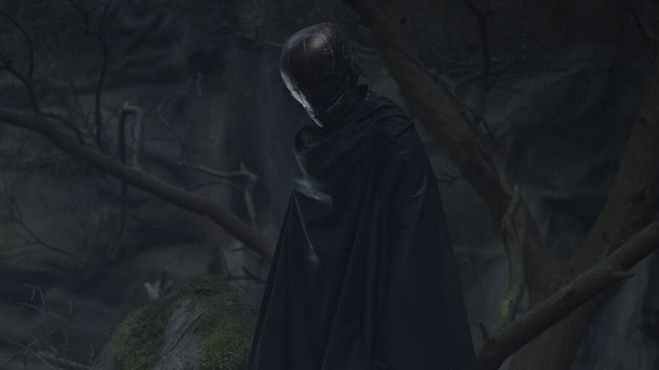 The Acolyte Folge 5 Tag: Auf dem Bild ist eine finstere Gestalt im schwarzen Umhang und ledernen Helm zu sehen. Im Hintergrund ist eine Felswand und Äste