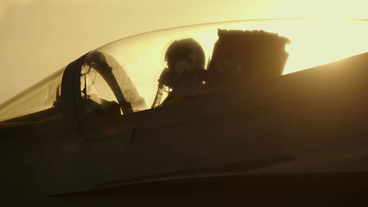 Top Gun: Maverick: Auf dem Bild ist ein Flugzeug zu sehen. Ein Pilot in voller Montur mit Helm sitzt darin. Das Verdeckt des Flugzeuges ist geschlossen. Die Sonne strahlt das Flugzeug an, sodass nur die Silhouette von allem zu sehen ist