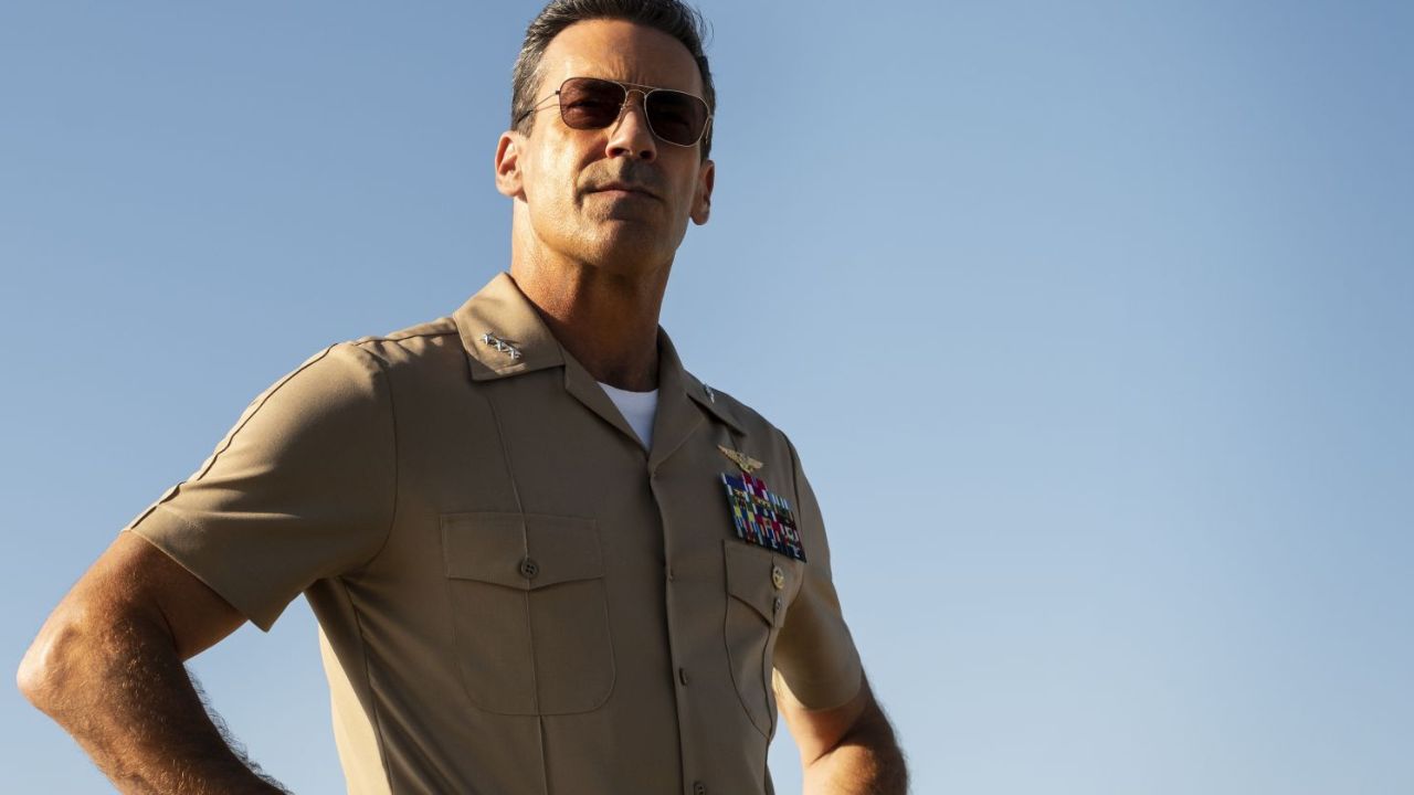 Top Gun: Maverick: Das Bild zeigt einen Mann in Uniform und Sonnenbrille. Er hat die Arme in die Hüften gestemmt