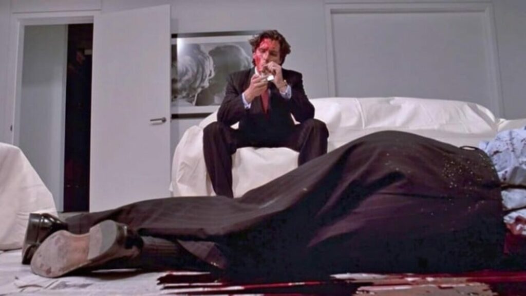 Patrick Bateman (Christian Bale) sitzt auf einem Sofa, vor ihm eine Leiche. | Die 5 besten Filme von Regisseurinnen