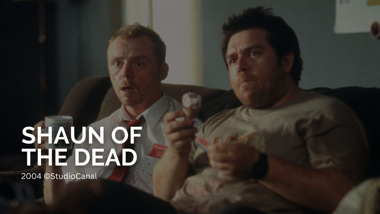 Die besten Film-Trilogien aller Zeiten: Shaun of the Dead: Auf dem Bild sitzen zwei Männer auf der Couch. Einer hat eine Kaffeetasse in der Hand der andere ein Cornetto Eis. Beide starren entsetzt auf den Fernseher