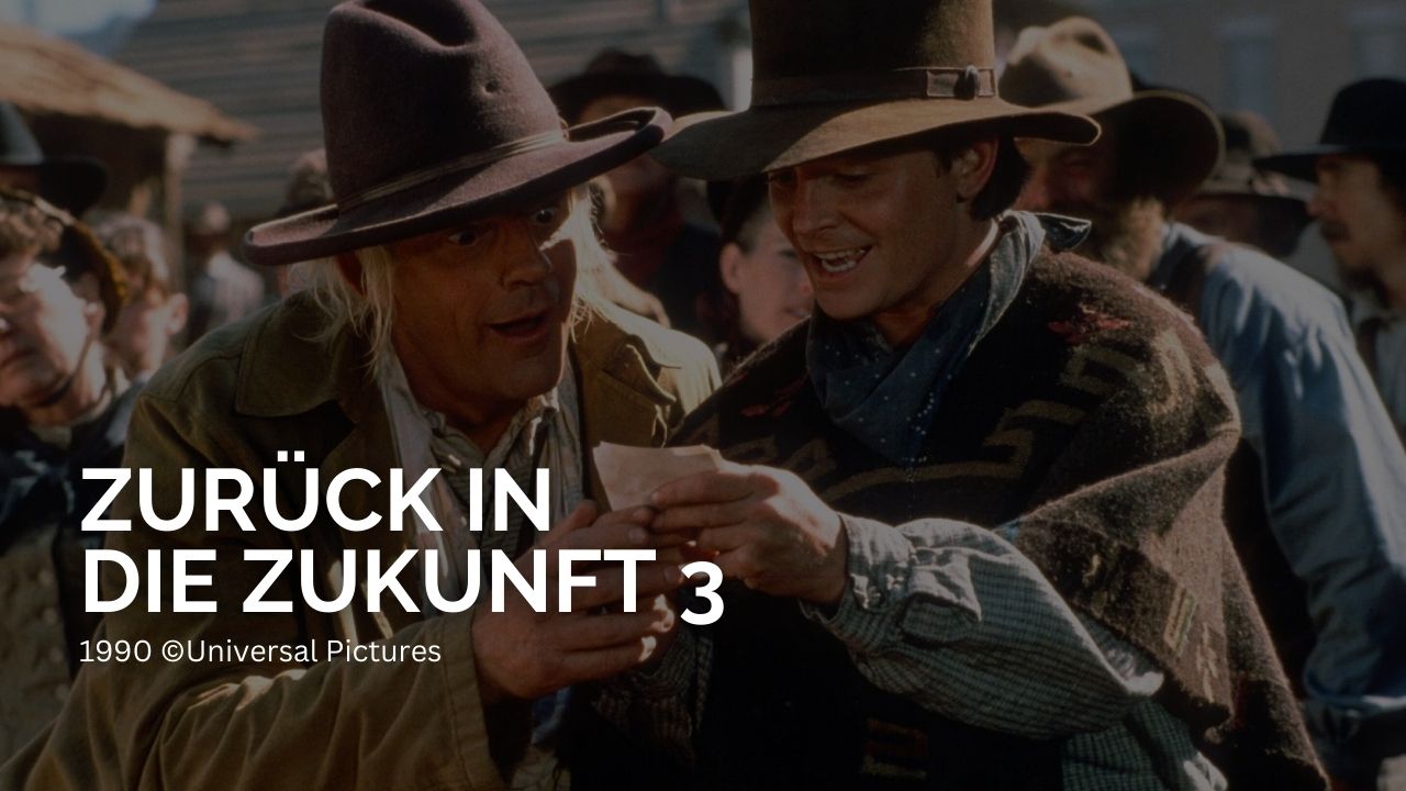 Die besten Film-Trilogien aller Zeiten | Zurück in die Zukunft 3: Auf dem Bild ist ein junger und ein alter Cowboy. Beide schauen auf ein Stück Papier und freuen sich