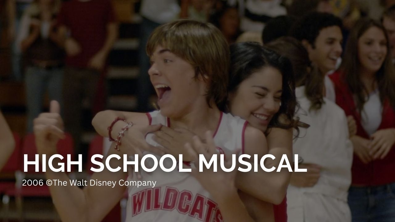 High School Musical. Auf dem Bild umarmt ein Mädchen einen Jungen von Hinten, der gerade jubelt. Er trägt ein Trikot mit der Aufschrift "Wildcats" | Die besten Film-Trilogien aller Zeiten