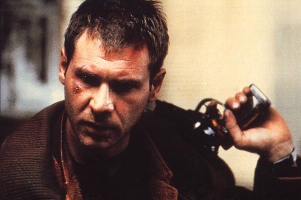 Blade Runner: Ein Mann mit ernster Miene und Verletzung im Gesicht, bekleidet mit einem dunklen Mantel, hält eine futuristische Waffe in der Hand. Die Szene wirkt düster und intensiv, was auf eine actionreiche oder bedrohliche Situation hinweist.