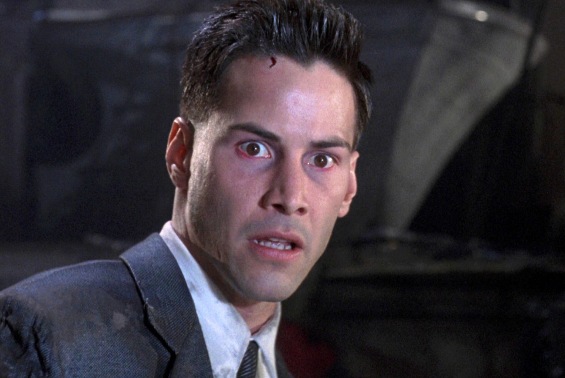 Johnny Mnemonic: Auf dem Bild ist ein Mann, der ziemlich erschöpft und krank aussieht. Er macht einen entsetzten Gesichtsausdruck