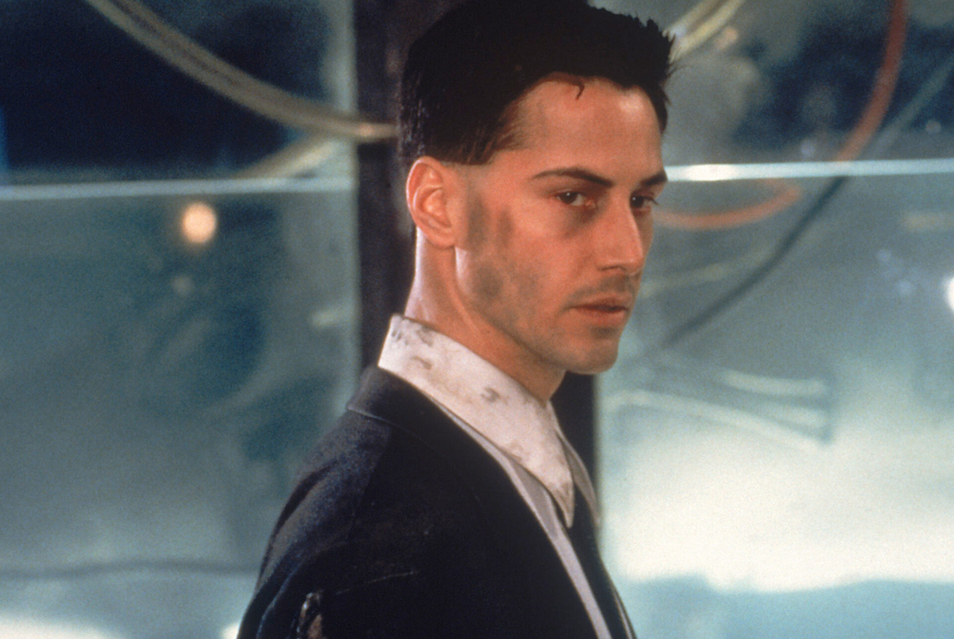 Das Bild zeigt Johnny Mnemonic, der erschöpft wirkt und schmutzig im Gesicht ist