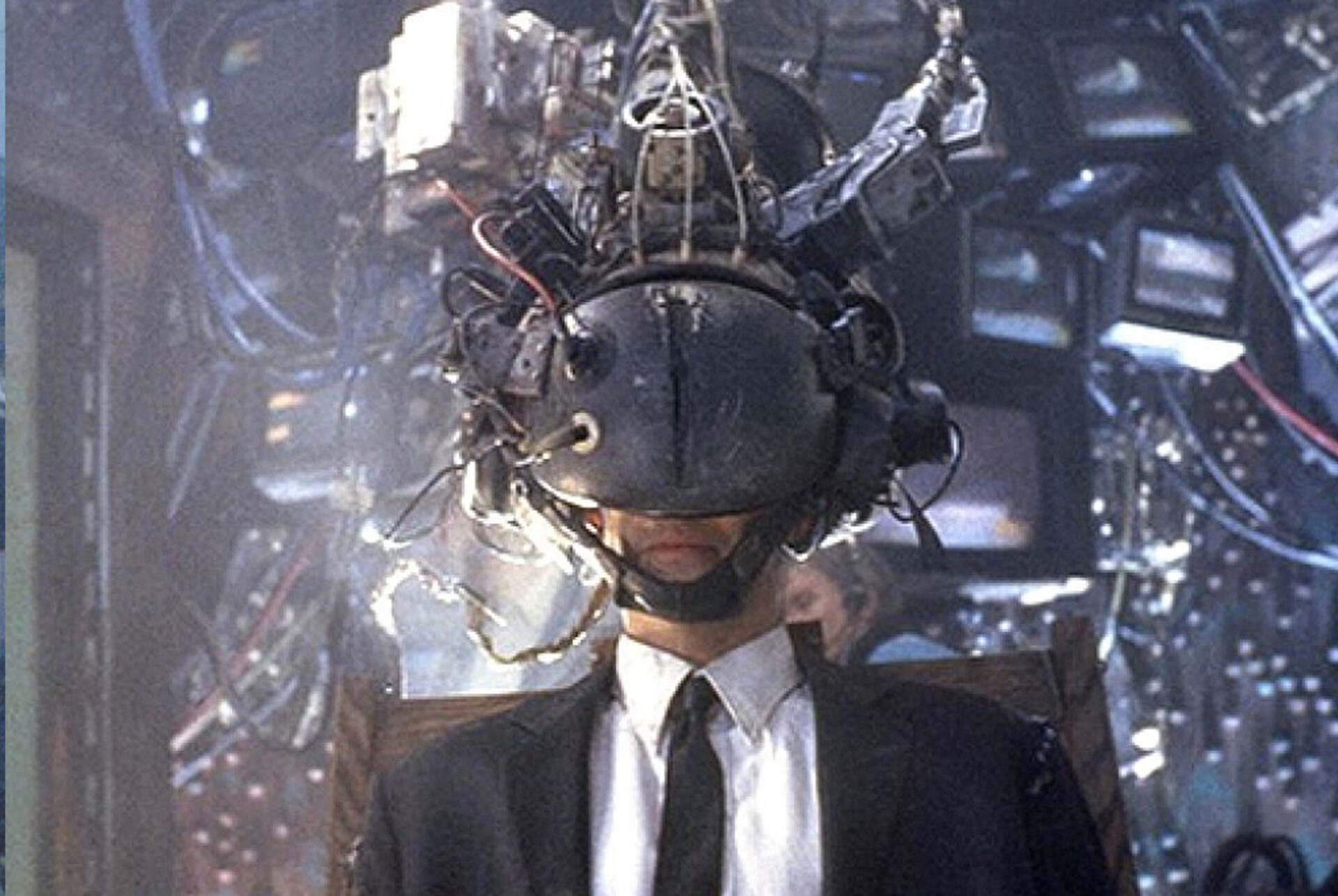 Auf dem Bild ist ein Mann, der einen Cyberhelm mit vielen Kabeln trägt