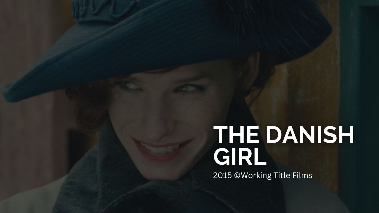 The Danish Girl: Das Bild zeigt eine lächelnde Transfrau im blauen Kostüm und dazu passenden Hut. Auf der rechten Seite des Bildes steht in weißen Lettern "The Danish Girl" und kleiner darunter "2015 ©Working Title Films"  Deine 5 liebsten Darsteller und ihre besten Rollen