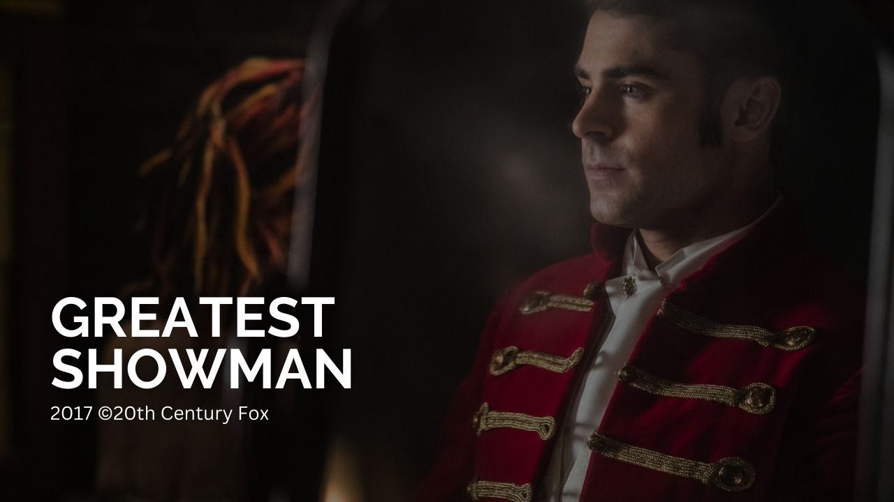 Greatest Showman: Das Bild zeigt einen jungen Mann in Zirkusdirektorjacke. Auf der linken Seite des Bildes steht in weißen Lettern "Greatest Showman" und kleiner darunter "2017 ©20th Century Fox"