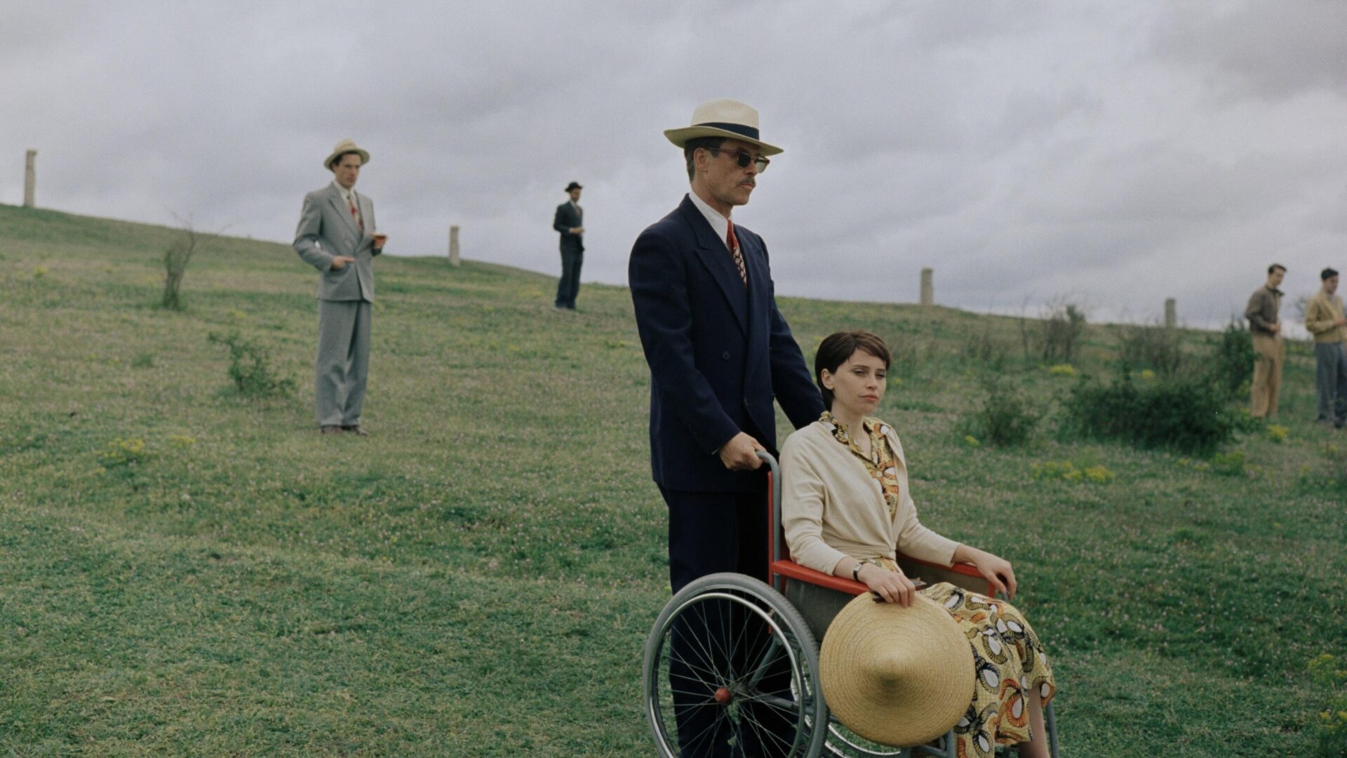 Harrison Lee Van Buren (Guy Pearce) schiebt Erzsébet Tóth (Felicity Jones) mit einem Rollstuhl über einen grasigen Hügel.