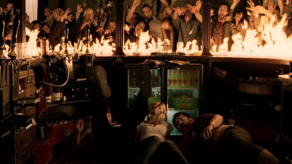 Shaun of the Dead | 3 Personen liegen auf dem Boden einer brennenden Bar. Hinter der Bar eine Horde Zombies. | Media Monday #716