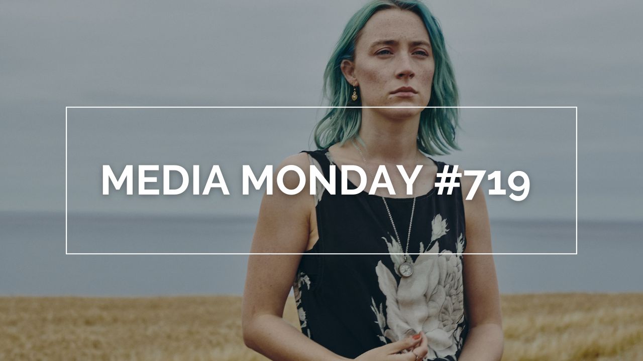 Auf dem Bild ist Rona mit blauen Haaren, auf einem Feld stehend. Im Hintergrund ist das Meer. Sie trägt einen kleinen Kompass um den Hals. Auf dem Bild steht in weißen Lettern "Media Monday #719" in einem weißen Rahmen