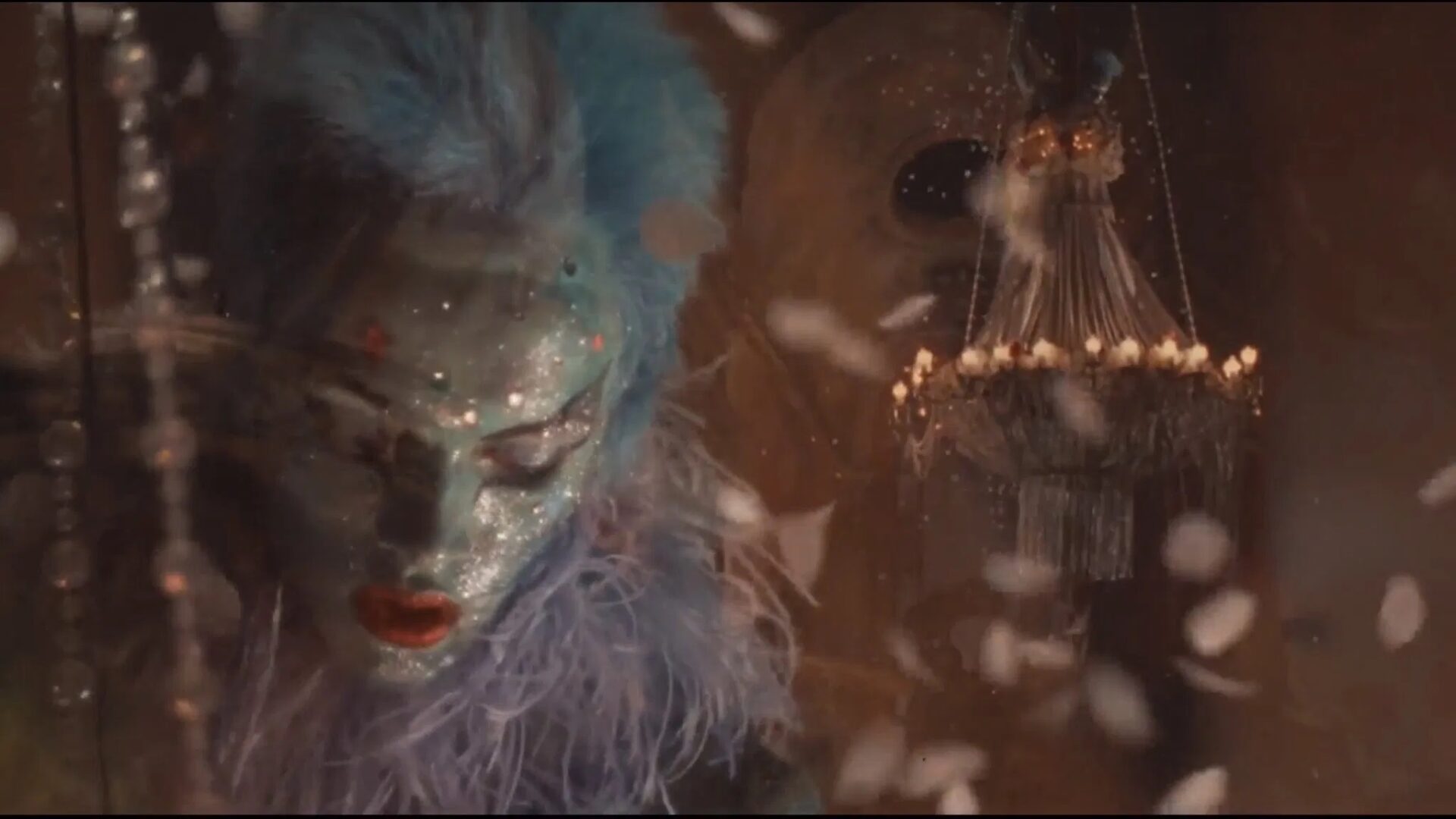 Das Bild zeigt eine Person mit blau bemalten Gesicht und blauen Haaren umgeben von Glitzer | 90er Jahre Kino: Die 5 besten Filme aus den 90er Jahren
