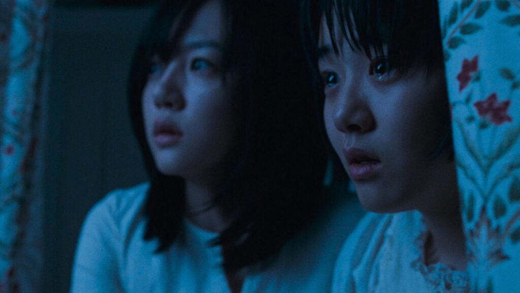 Die beiden Schwestern Su-mi und Su-yeon schauen verängstigt aus dem Bild