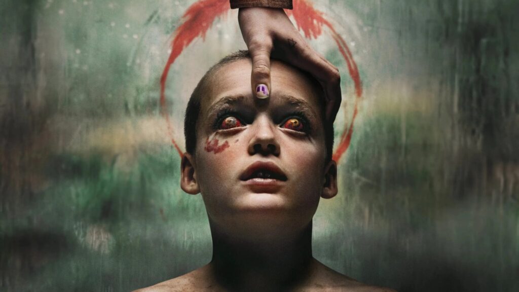 Das Bild zeigt Jonah Wren Phillips als Oliver mit blutunterlaufenden Augen. Ein Hand ist auf seine Stirn gelegt. Um seinen Kopf ist wie eine Art Krone ein Kranz aus Blut abgebildet. Das Bild ist das Titelposter des Films "Bring Her Back" | Media Monday #741