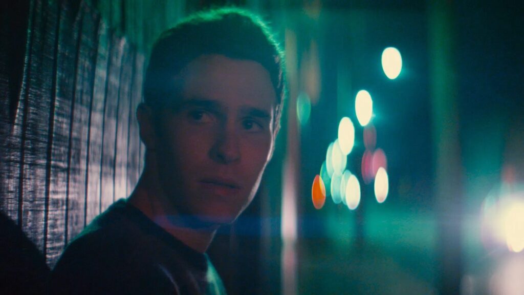 Das Bild zeigt einen jungen Mann im Neonlicht