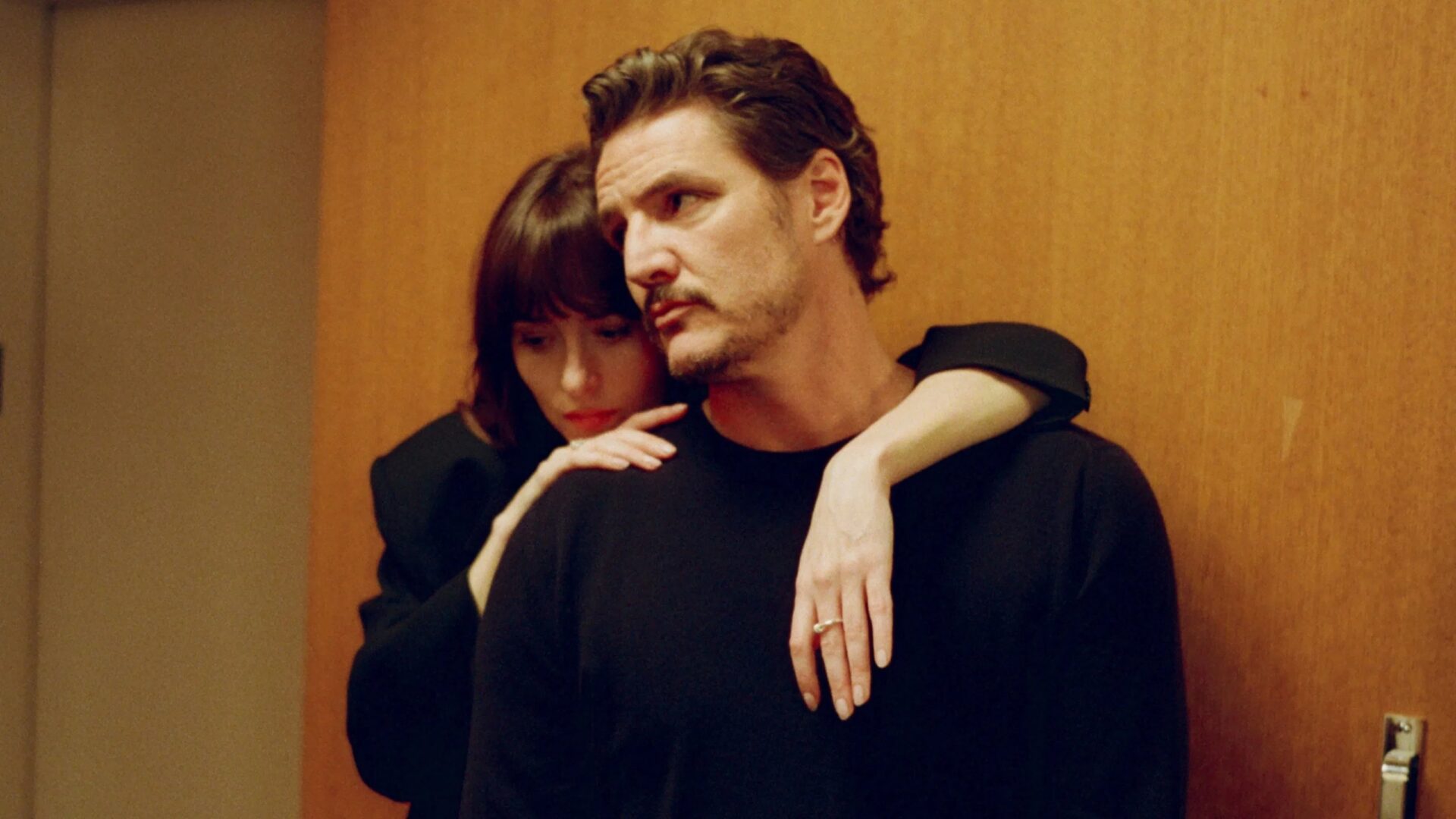 Auf dem Bild sind Dakota Johnson und Pedro Pascal abgebildet. Sie umarmt ihn innig von hinten