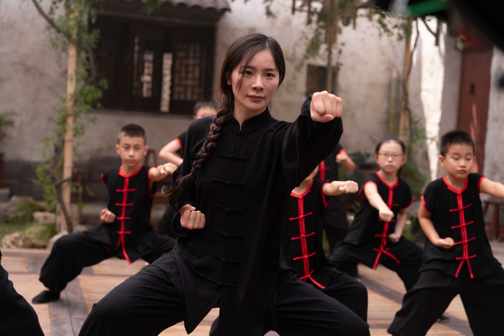 Yaxi Liu steht vor mehreren Kindern und bringt ihnen Kampfkunst bei. Szene aus dem Film "Kung Fu in Rome".